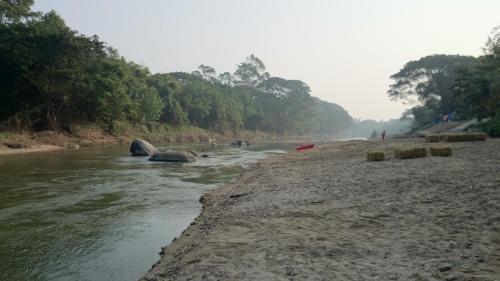 a river with people walking on the side of it at Baantantara in Suan Phung