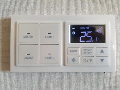 a white remote control with a digital clock on it at Seogwipo KAL Hotel in Seogwipo
