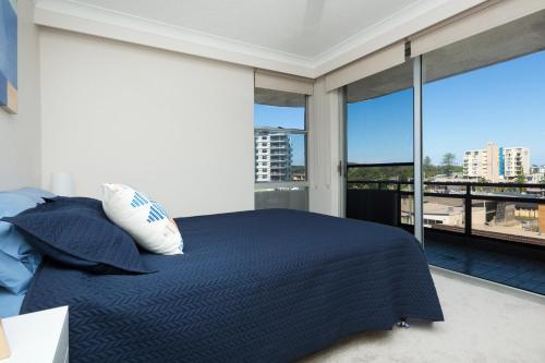 a bedroom with a bed and a large window at Sandbar unit 401 in Forster
