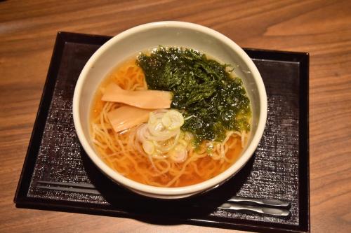 a bowl of noodles and vegetables on a plate at Dormy Inn Premium Otaru in Otaru