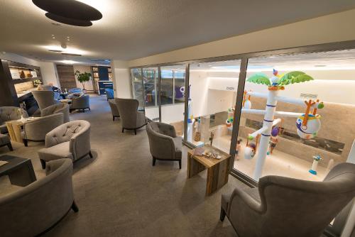a waiting room with chairs and an aquarium with an umbrella at Hotel Sporting Family Hospitality in Livigno