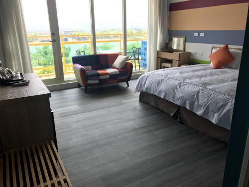a bedroom with a bed and a chair and windows at The Riverview Retreats in Wujie