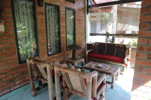 a porch with chairs and a table and a couch at Princess Cottages in Sukabumi