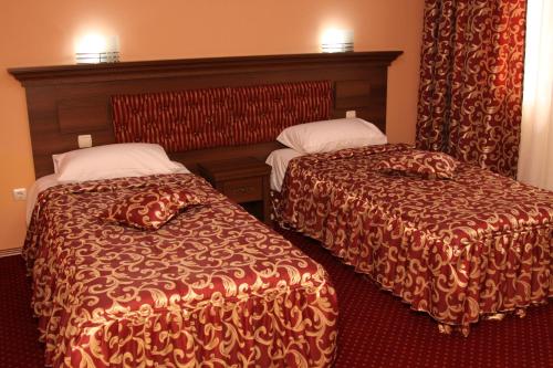 a hotel room with two beds in a room at Hotel Park Bachinovo in Blagoevgrad
