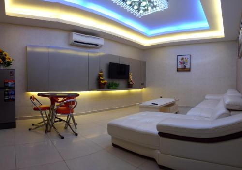 a room with a bed and a table and a tv at Golden Leaves Hotel in Malacca