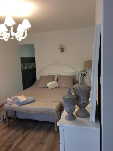 a bedroom with a bed and a table with a vase at Au charmant des vignes in Montagne