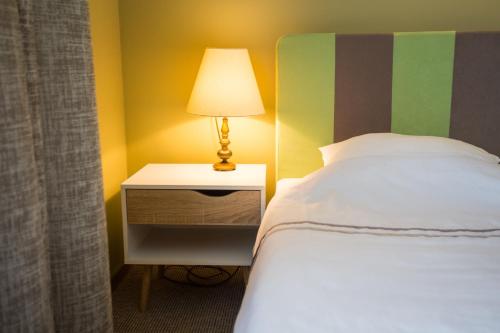 a bedroom with a bed and a lamp on a night stand at Irbēni in Brivkalni