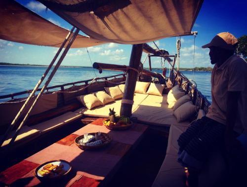 a man standing on a boat with a table on it at Rock and Sea Resort in Watamu