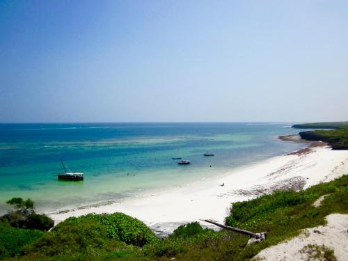 a view of a beach with boats in the water at Rock and Sea Resort in Watamu