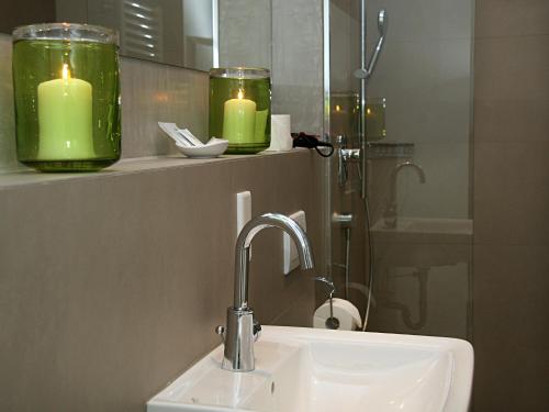 a bathroom with two green candles and a sink at Hotel Gasthof Alte Post - Restaurant offen in Oberding