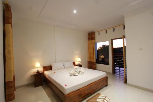 a bedroom with a bed and a large window at Bali Bening in Munduk