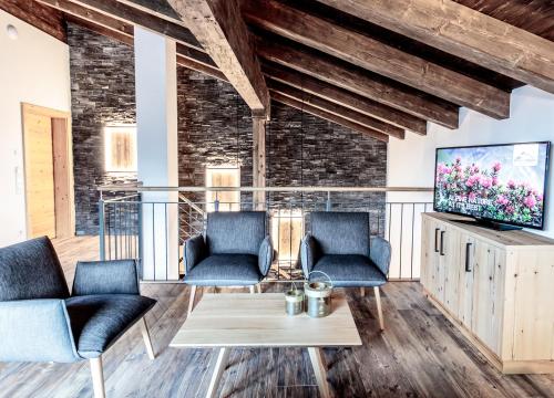 a living room with two chairs and a tv at die Schneiderei in Kaprun