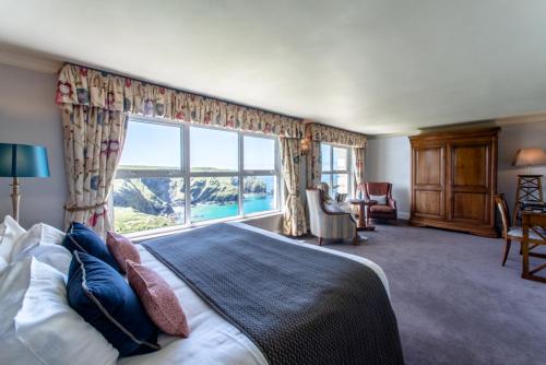 a bedroom with a bed and a large window at Mullion Cove Hotel & Spa in Mullion