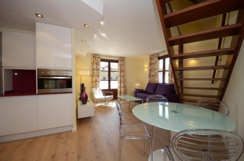 a kitchen and living room with a table and chairs at Apartamentos El Palacete de Ainsa in Aínsa