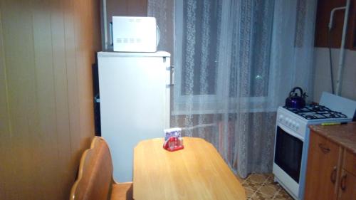 ズラトウーストにあるApartment on Gagrina pr-tの小さなキッチン(テーブル、冷蔵庫付)