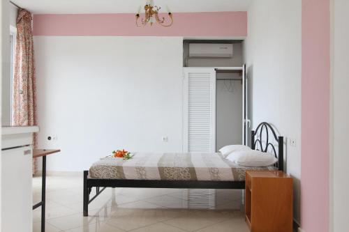 a bedroom with a bed and a pink wall at Madalenas B&B in Pelekas