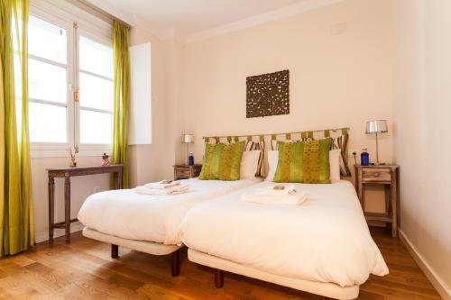 two beds in a room with two windows at City Rooftop Paradise - Space Maison Apartments in Seville