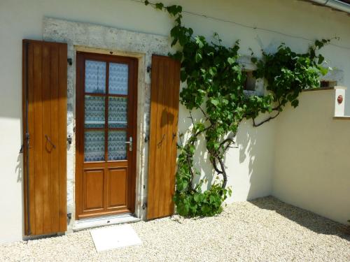 a door to a building with ivy growing around it at La Vieille Gorce Gîtes in the Vienne in Asnois