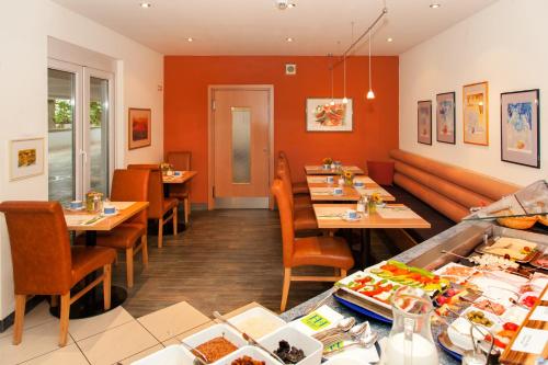 a restaurant with tables and chairs in a room at Hotel Plaza in Frankfurt/Main