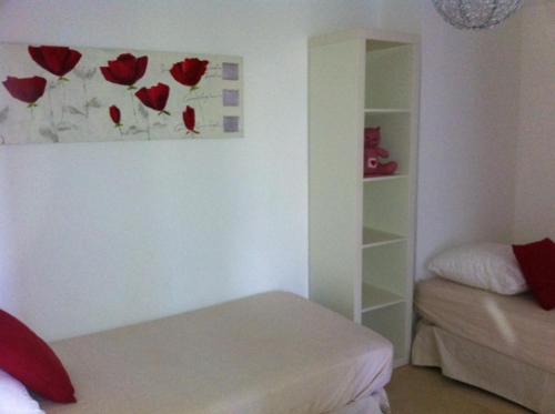a room with a bed and a painting of roses on the wall at Villa W in Cassis