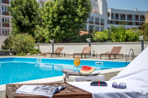 a table with a glass of juice and a slice of watermelon on it at Hotel Capannelle Roma in Rome