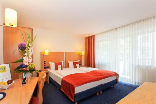 a hotel room with a bed and a desk at Hotel Plaza in Frankfurt/Main