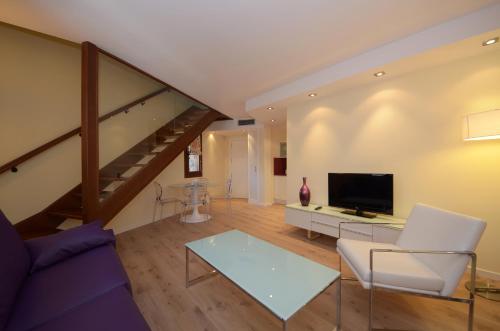 a living room with a couch and a tv at Apartamentos El Palacete de Ainsa in Aínsa