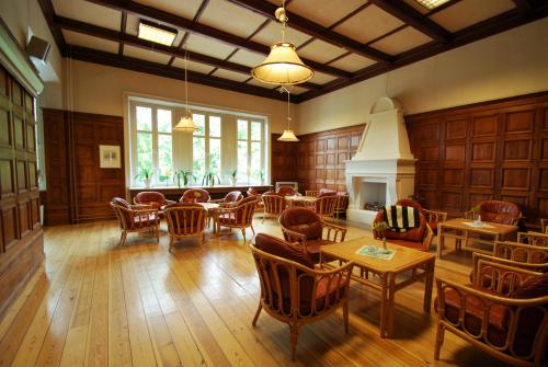 a large room with tables and chairs and a fireplace at Hellidens Slott in Tidaholm