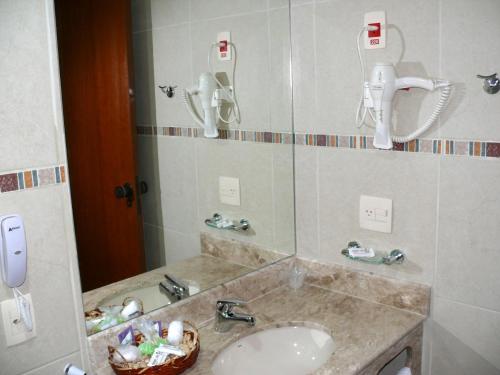 y baño con lavabo y espejo. en Casa do Sol Hotel, en Petrópolis