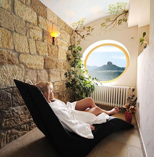 a woman laying in a hammock in a room at Panoramahotel Wolfsberg in Bad Schandau