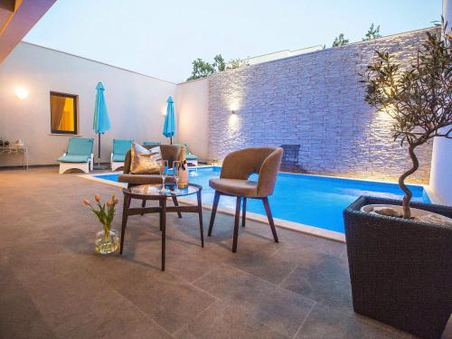 - un salon avec une piscine, une table et des chaises dans l'établissement Luxury Rooms Pino, à Split