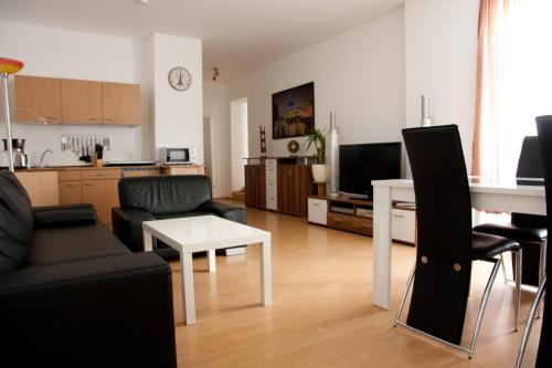 - un salon avec un canapé et une table dans l'établissement Apartments City Room Berlin, à Berlin
