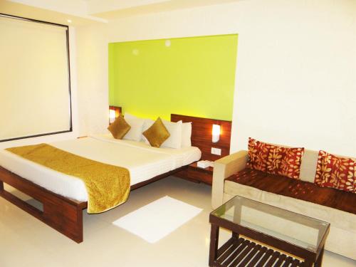 a hotel room with a bed and a couch at The Temple View Hotel in Shirdi