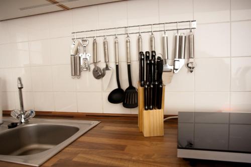 a kitchen with a bunch of utensils hanging on a wall at Apartments City Room Berlin in Berlin