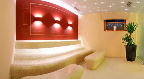 a lobby with a bench and a red wall at Hotel Zum Stern - Bergbahnen inklusive im Sommer 2025 in Bad Hofgastein