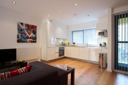 a living room with a couch and a kitchen at Miles Place by Viridian Apartments in London