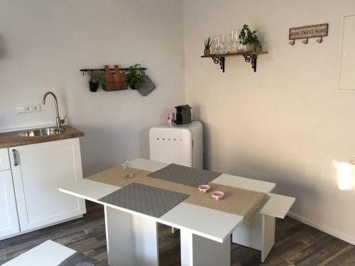 a kitchen with a white table and a refrigerator at Ferienwohnung Freiburg und March in Holzhausen