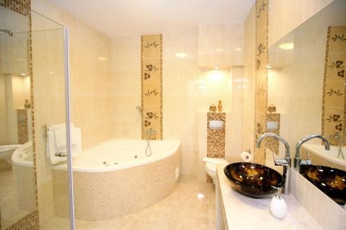 een badkamer met een bad en een wastafel bij Hotel Srebrna Góra in Srebrna Góra