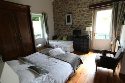a bedroom with a large bed and a brick wall at Maison Aretxola in Sare