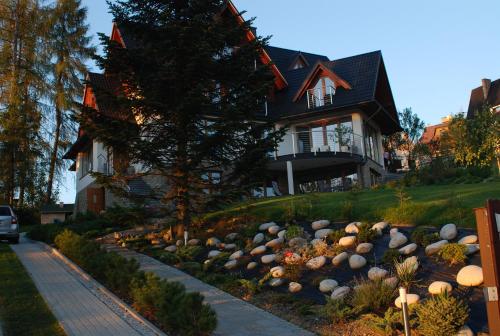 a house with a garden of rocks in front of it at Villa Park in Bukowina Tatrzańska