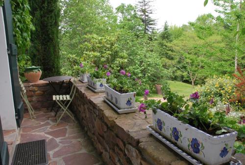 a garden with a row of flowerpots on a brick wall at Maison Aretxola in Sare