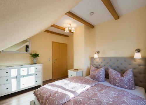 a bedroom with a bed and a dresser and a mirror at Bellevue Ferienwohnungen in Quedlinburg