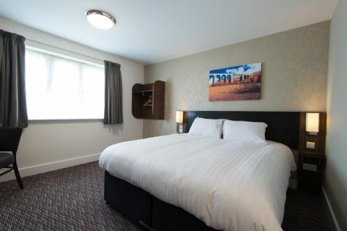 a hotel room with a large bed and a window at Kings Chamber, Doncaster by Marston's Inns in Doncaster