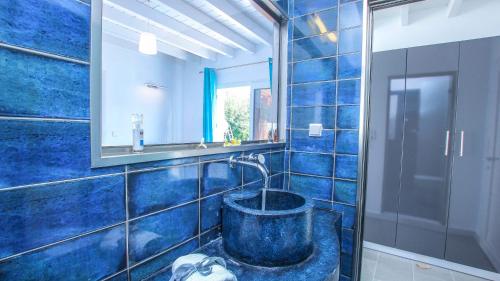 イクシアにあるVilla Elpinikiの青いタイル張りのバスルーム(バスタブ、鏡付)