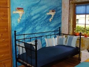 Schlafzimmer mit einem Bett mit Wandgemälde in der Unterkunft Haus Silbermond in Rust
