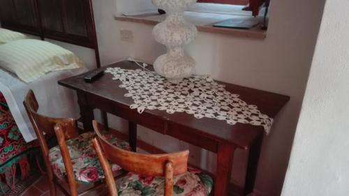 a table with two chairs and a vase on it at Agriturismo Cerquaglia in Todi