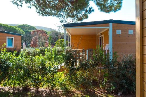 a house with a garden in front of it at Camping Lacona Pineta in Capoliveri