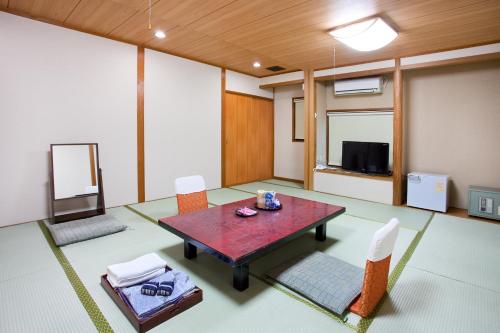 琴平町にあるこんぴら温泉　つるや旅館のテーブルと椅子とテレビのある部屋