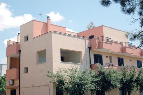 a pink building with trees in front of it at Vittoria Resort Residence-B&B in Galatina
