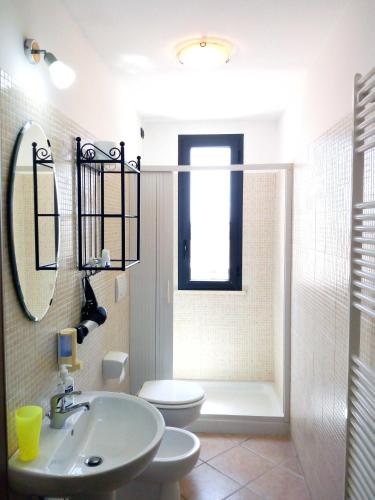 a bathroom with a sink and a toilet and a mirror at Vittoria Resort Residence-B&B in Galatina